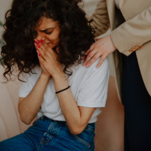 woman holding friend crying while grieving